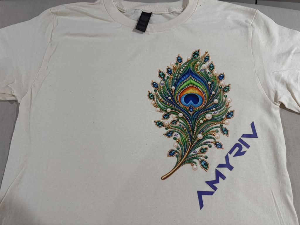 Peacock artwork tee. A colorful feather illustration printed as a statement graphic.